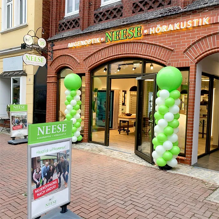 Eingang Optiker NEESE Augenoptik Hörakustik mit grünen Ballonsäulen